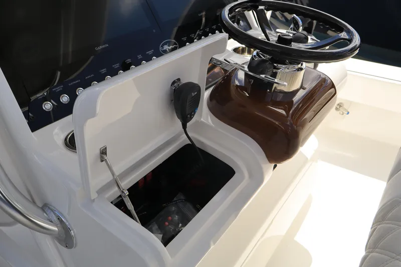 Slide: The Image of 2024 Valhalla Boatworks V-28 helm station with open storage compartment and steering wheel. - 11