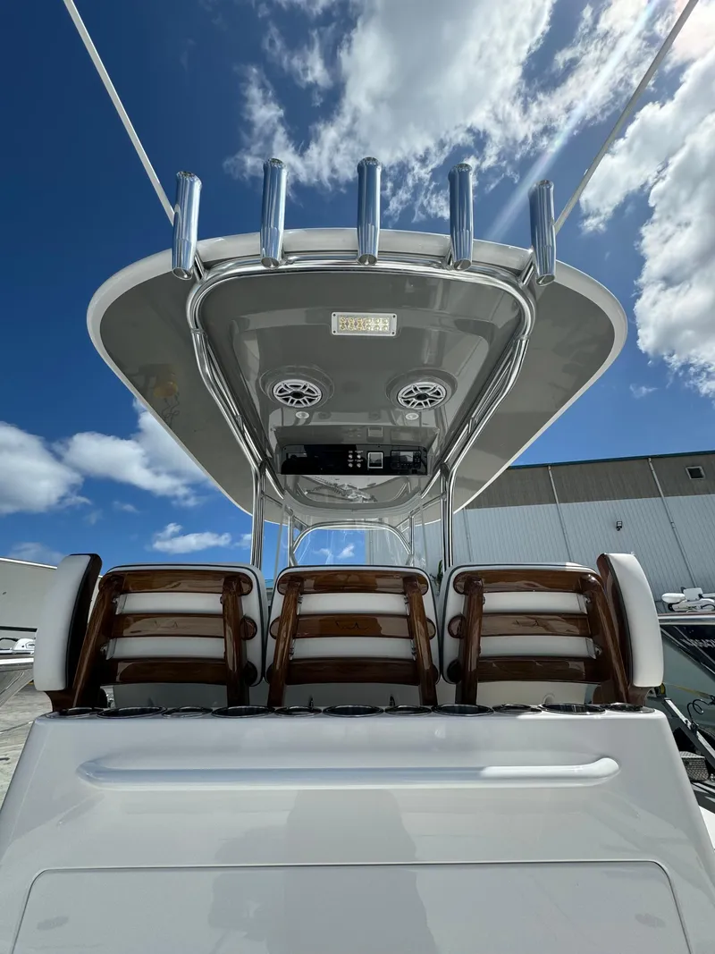 Slide: The Image of 2024 Valhalla Boatworks V-28 center console with rod holders and seating, under a blue sky. - 2