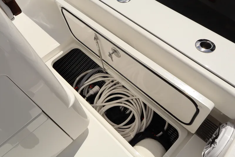 Slide: The Image of Storage compartment on the 2024 Valhalla Boatworks V-28, featuring coiled hoses. - 25