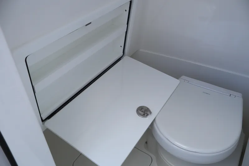 Slide: The Image of 2024 Valhalla Boatworks V-28 bathroom with white toilet and foldable shelf. - 37