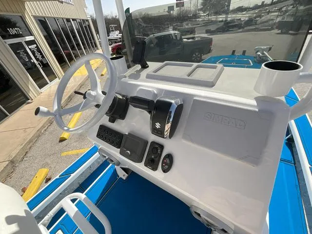 Slide: The Image of 2024 Majek 25 ILLUSION boat dashboard with steering wheel and controls, parked outdoors. - 10