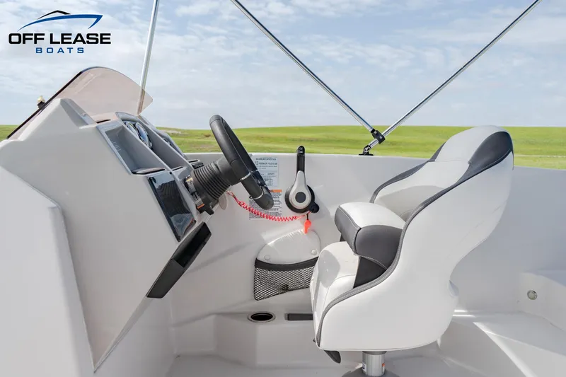 Slide: The Image of 2022 Starcraft SVX 191 OB boat cockpit with steering wheel and captain's chair. - 8