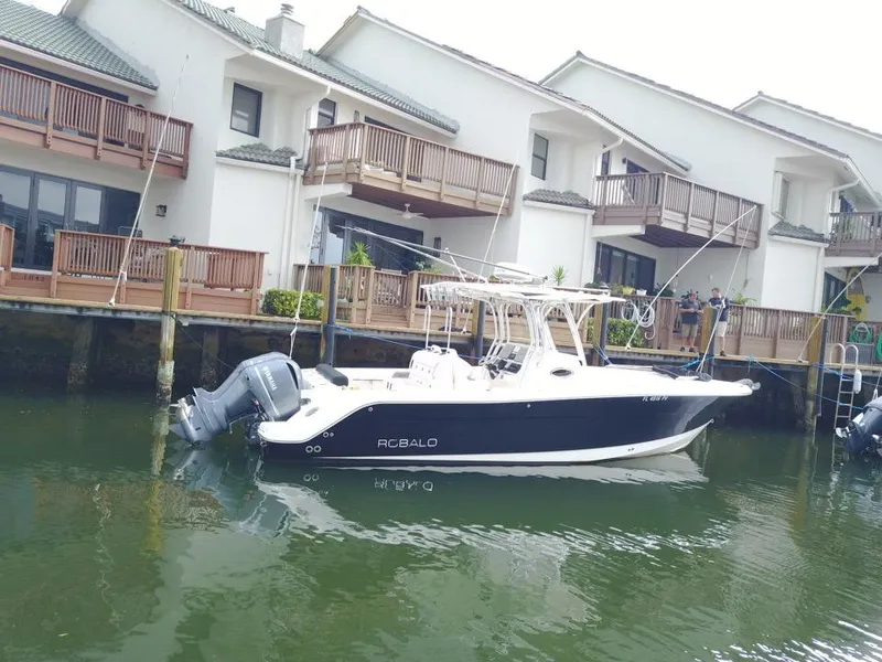 Slide: The Image of 2015 Robalo R300 Center Console boat docked near waterfront homes. - 2
