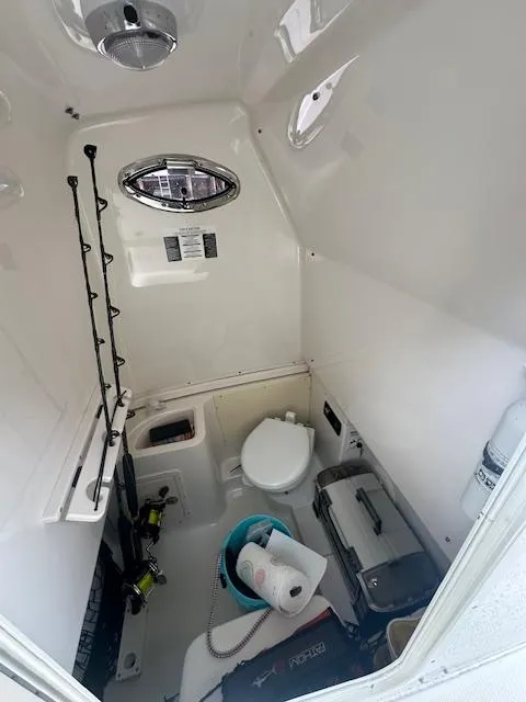 Slide: The Image of 2015 Robalo R300 Center Console interior cabin with toilet and storage. - 5