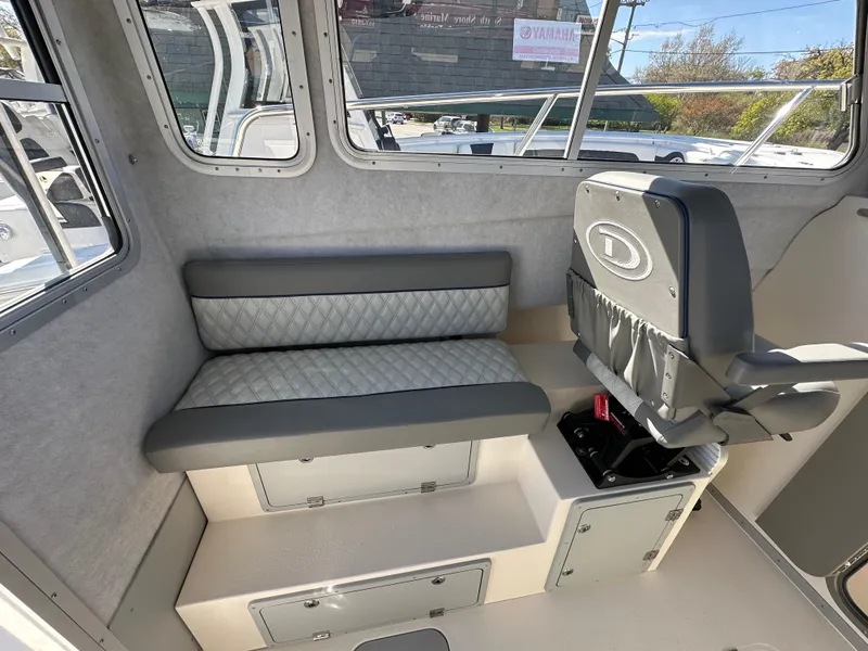 Slide: The Image of Interior seating of 2024 Defiance Admiral 270 EX boat with gray upholstery. - 11