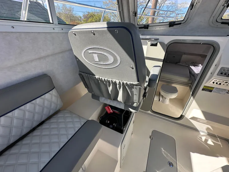 Slide: The Image of Interior of 2024 Defiance Admiral 270 EX boat with seating and cabin area. - 12