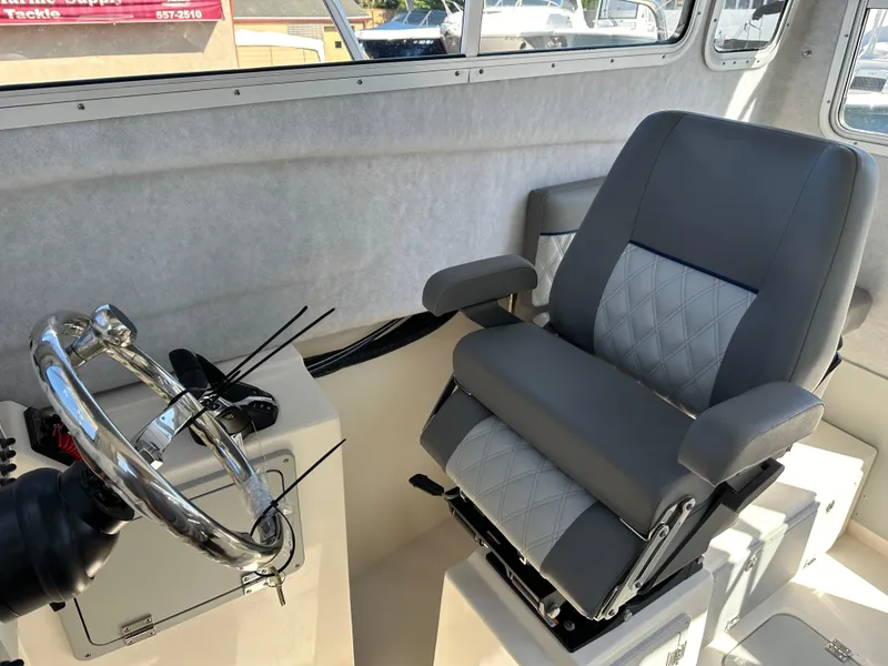 Slide: The Image of Captain's chair and helm of 2024 Defiance Admiral 270 EX boat. - 22