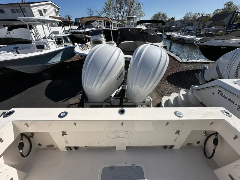 Slide: The Image of 2024 Defiance Admiral 270 EX boat with twin outboard engines at a marina. - 3