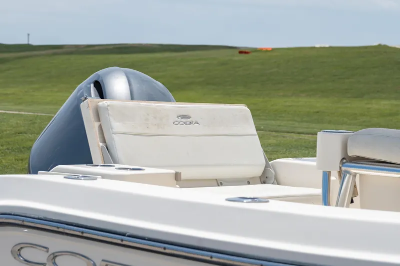 Slide: The Image of 2021 Cobia 201 Center Console boat with cushioned seating and outboard motor. - 9