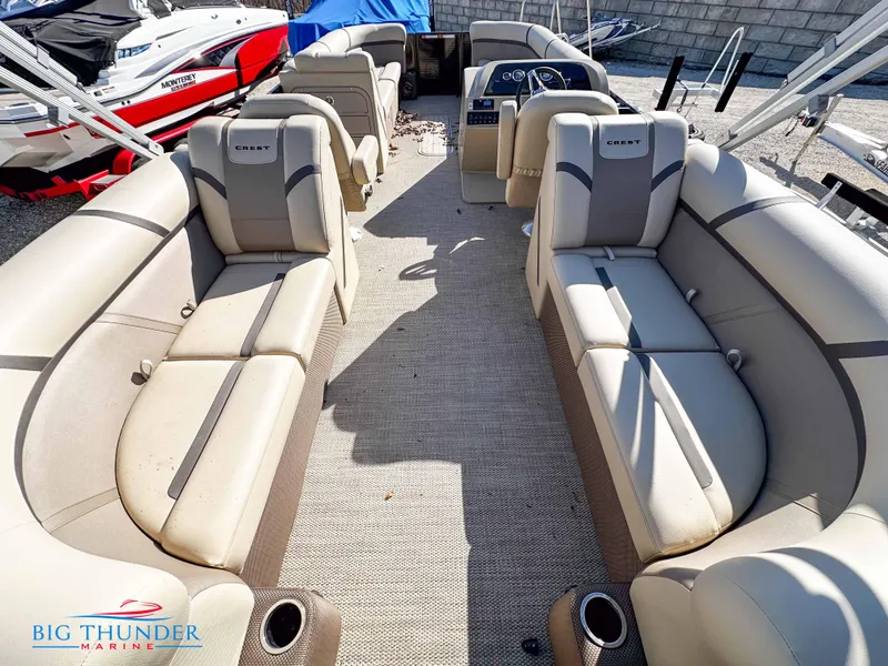 Slide: The Image of 2023 Crest CLASSIC LX 240 SLC pontoon boat interior with beige seating and steering console. - 3
