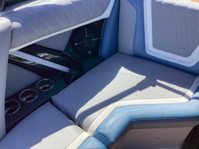 Slide: The Image of 2020 Tigé 21ZX boat interior with gray and blue upholstery, cup holders, and speaker. - 16