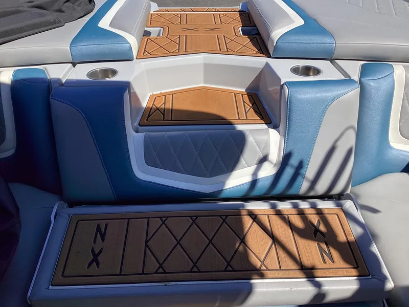Slide: The Image of 2020 Tigé 21ZX boat interior with blue and white seating and teak flooring. - 18