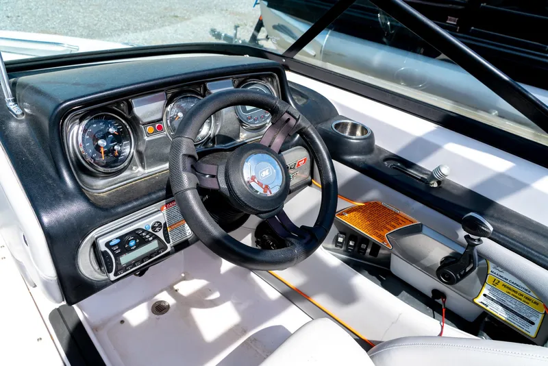 Slide: The Image of 2013 Nautique 210 SUPER AIR boat dashboard with steering wheel and control panel. - 19