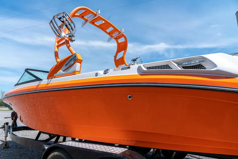Slide: The Image of 2013 Nautique 210 SUPER AIR boat with vibrant orange hull and wakeboard tower. - 4