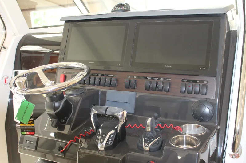 Slide: The Image of Control panel of the 2025 Pursuit S 358 Sport boat with dual screens and steering wheel. - 18