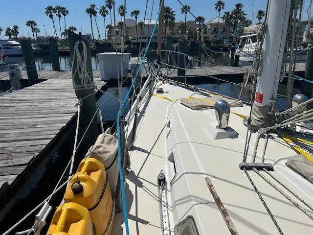Slide: The Image of 1988 Sabre 38 sailboat docked at marina with palm trees in background. - 10