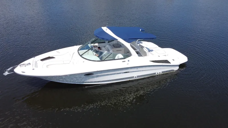 The Image of 2009 Sea Ray 300 SLX boat with blue canopy on calm water. - 0