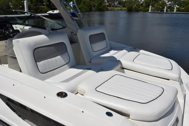Slide: The Image of 2009 Sea Ray 300 SLX boat with white cushioned seating by the water. - 12