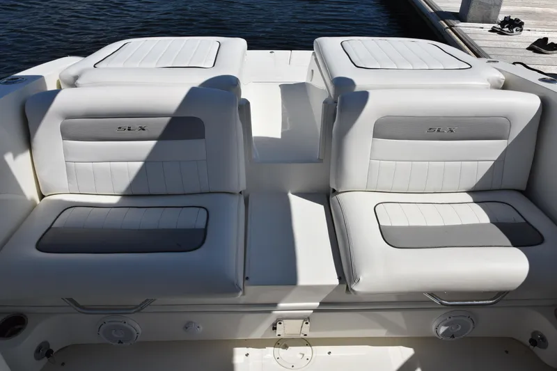 Slide: The Image of 2009 Sea Ray 300 SLX boat seats with white and gray upholstery by the water. - 16