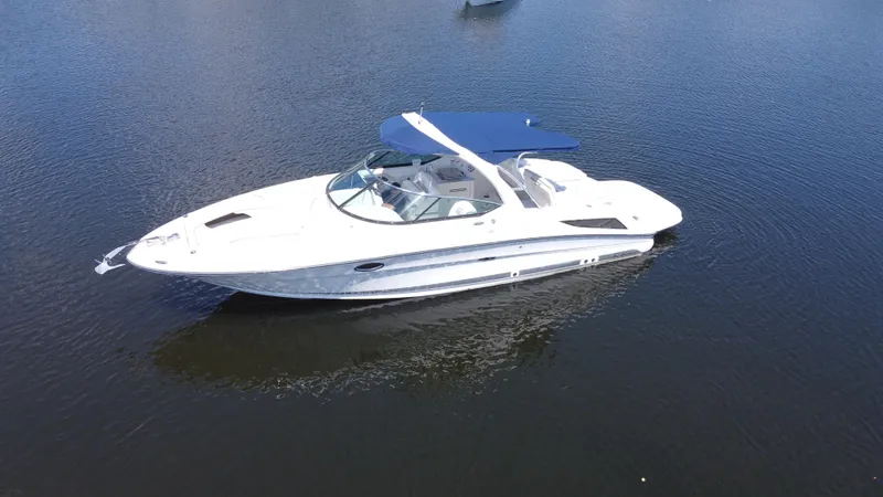 Slide: The Image of 2009 Sea Ray 300 SLX boat with blue canopy on calm water. - 2