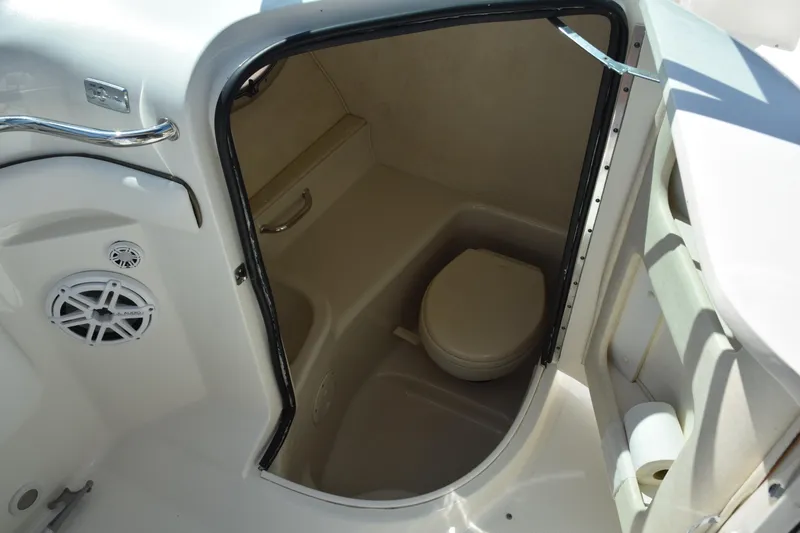 Slide: The Image of 2009 Sea Ray 300 SLX boat interior with compact marine toilet and storage space. - 26