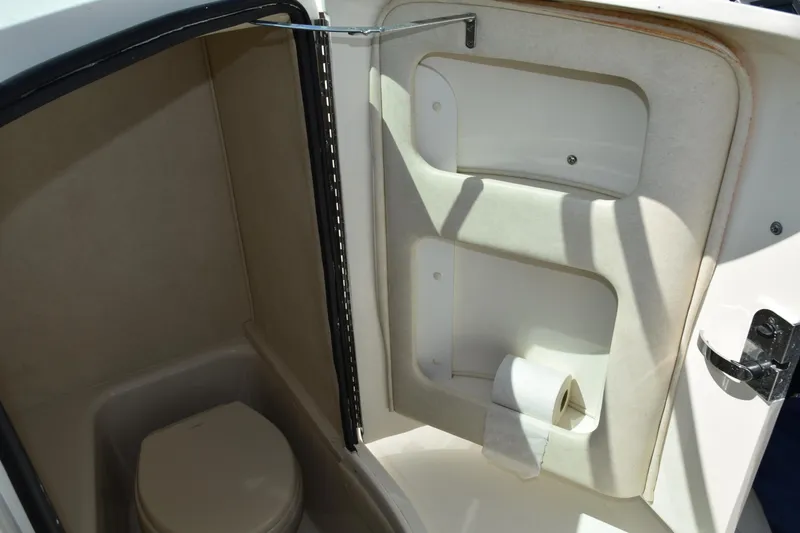 Slide: The Image of 2009 Sea Ray 300 SLX boat interior bathroom with toilet and storage shelves. - 28
