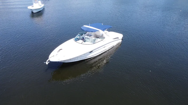 Slide: The Image of 2009 Sea Ray 300 SLX boat on calm water with blue canopy. - 3
