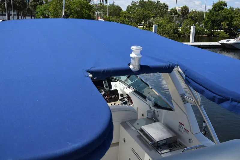 Slide: The Image of 2009 Sea Ray 300 SLX boat with blue canopy, docked near lush greenery. - 39