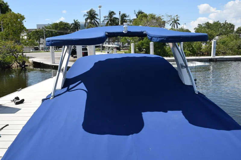 Slide: The Image of 2009 Sea Ray 300 SLX boat with blue cover docked by the water. - 45