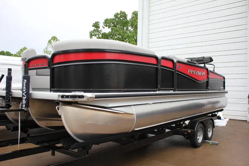 Slide: The Image of 2024 Premier 230 SunSation Angler pontoon boat on trailer, black and red design. - 10
