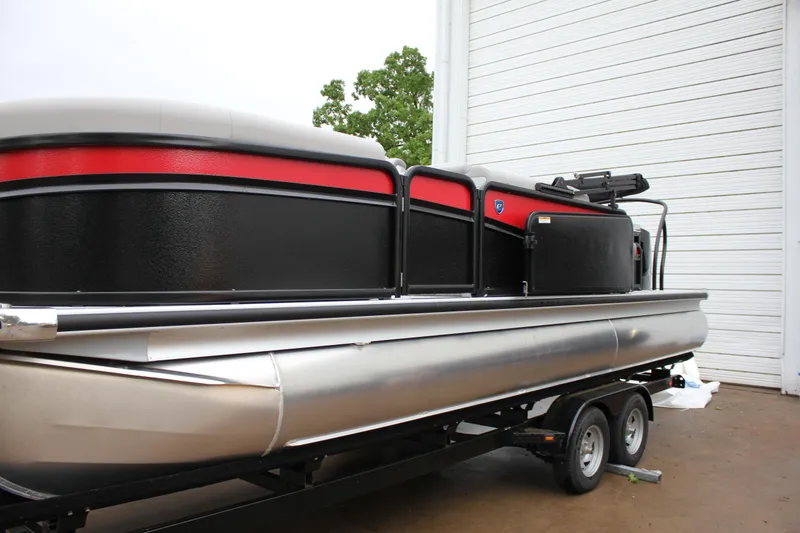 Slide: The Image of 2024 Premier 230 SunSation Angler pontoon boat on trailer, black and red exterior. - 17