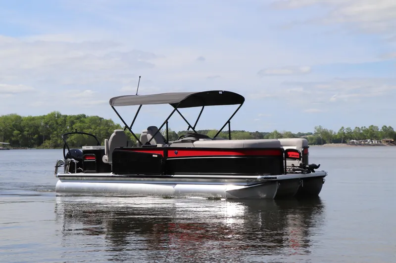 Slide: The Image of 2024 Premier 230 SunSation Angler pontoon boat on a calm lake. - 2