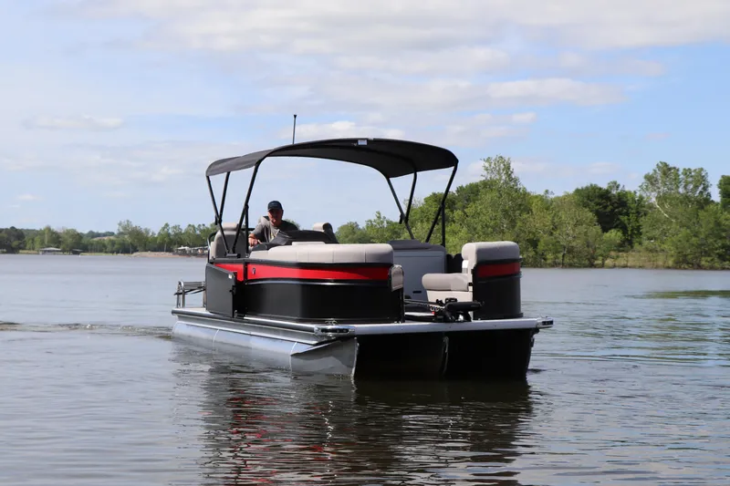 Slide: The Image of 2024 Premier 230 SunSation Angler pontoon boat cruising on a serene lake. - 3