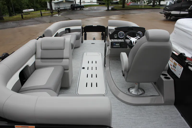 Slide: The Image of 2024 Premier 230 SunSation Angler pontoon boat interior with gray seating and modern dashboard. - 47