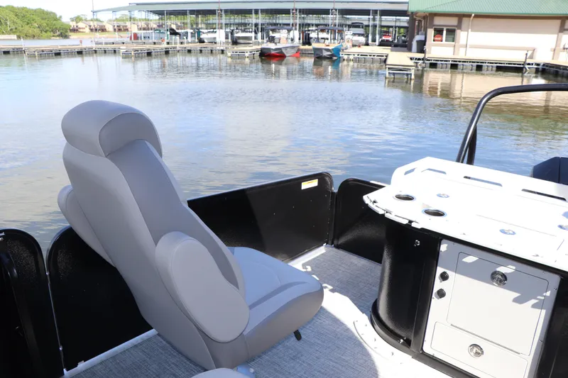 Slide: The Image of 2024 Premier 230 SunSation Angler boat interior with seating and fishing station by the water. - 8