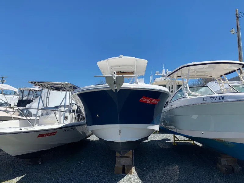 Slide: The Image of 2017 Edgewater 245 CC boat displayed between two other boats. - 1