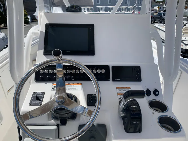 Slide: The Image of 2017 Edgewater 245 CC boat console with steering wheel, controls, and navigation display. - 11