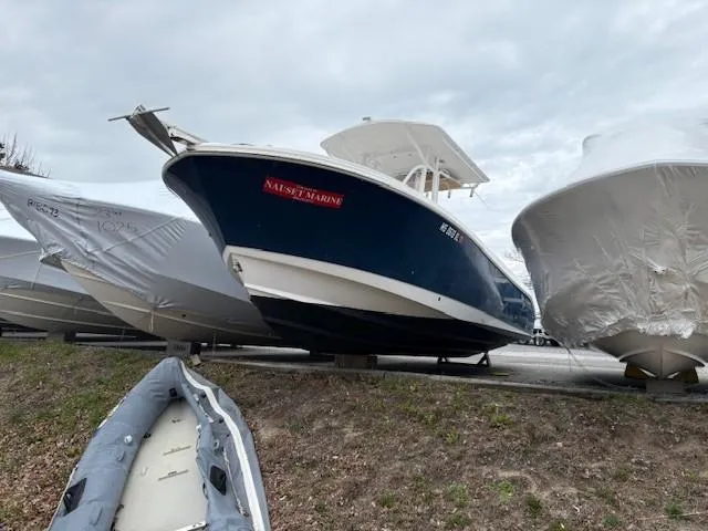 Slide: The Image of 2017 Edgewater 245 CC boat in storage, surrounded by covered vessels. - 12
