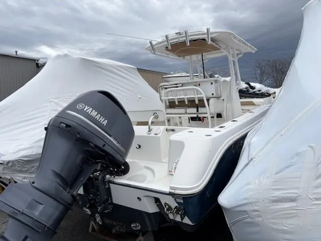 Slide: The Image of 2017 Edgewater 245 CC boat with Yamaha engine, partially covered, in storage. - 16