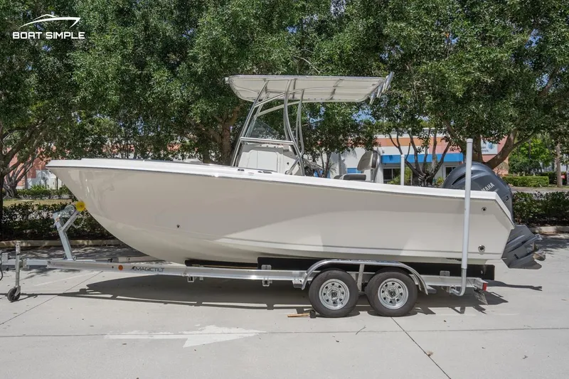 Slide: The Image of 2023 Sailfish 220 CC boat on trailer, parked outdoors, side view. - 0