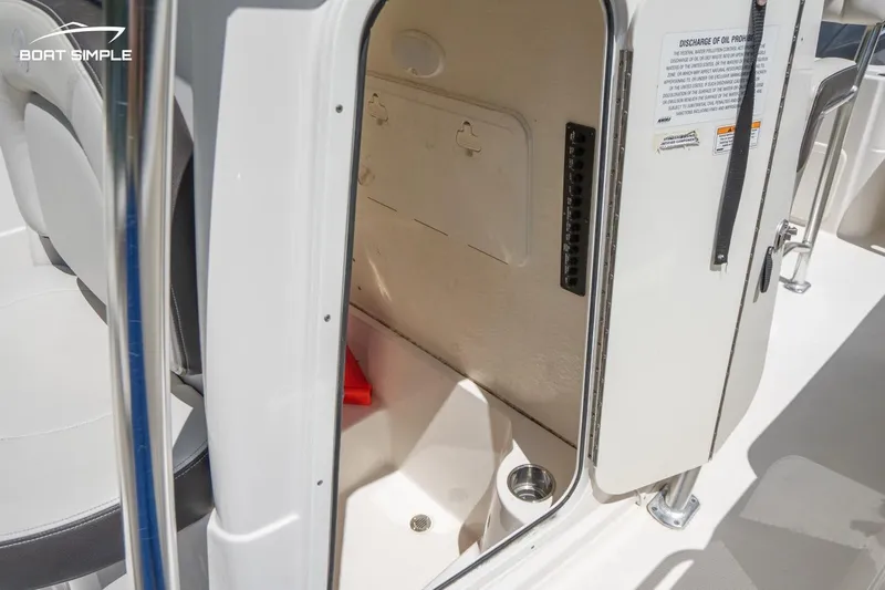 Slide: The Image of 2023 Sailfish 220 CC boat storage compartment with open door, showcasing interior space. - 15