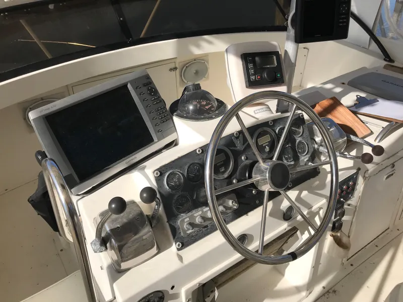 Slide: The Image of 1981 Bertram 35 Convertible helm with steering wheel, navigation equipment, and controls. - 10
