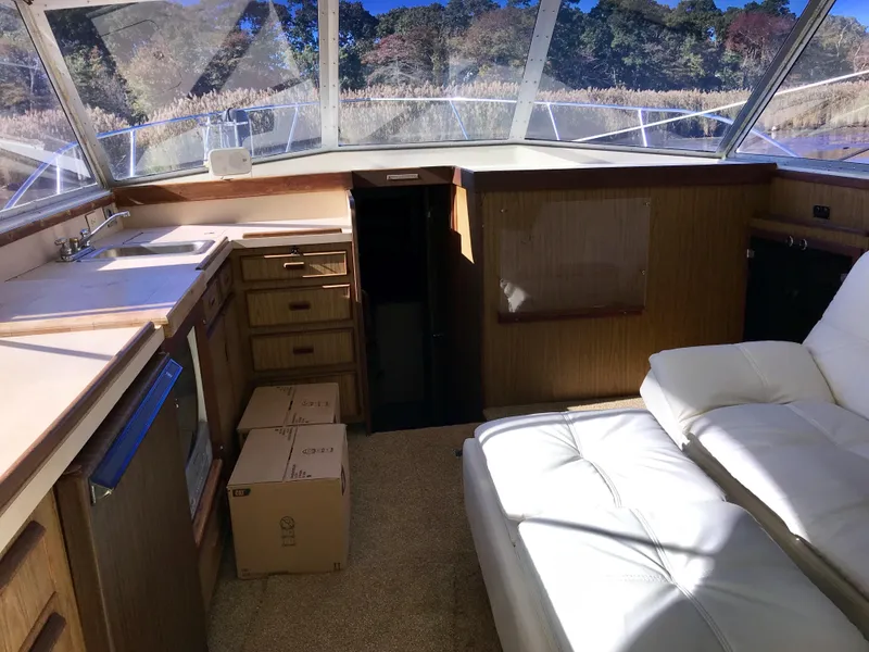 Slide: The Image of Interior of 1981 Bertram 35 Convertible boat with white seating and wooden cabinetry. - 5
