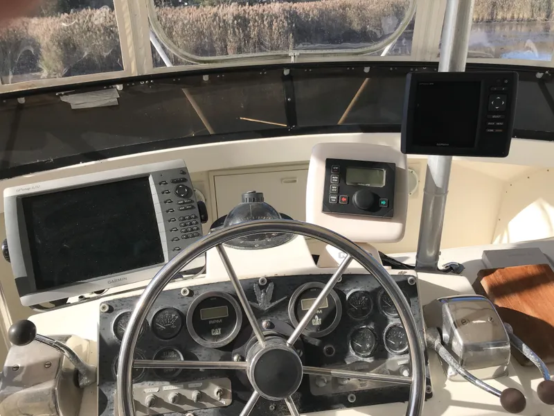 Slide: The Image of 1981 Bertram 35 Convertible boat dashboard with steering wheel and navigation instruments. - 9