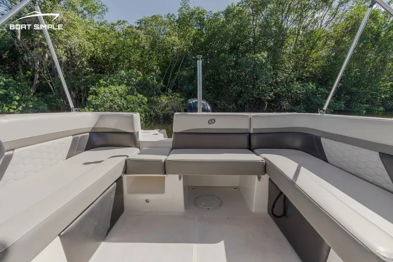 Slide: The Image of 2022 Hurricane 217 SD boat interior with spacious seating and lush greenery in the background. - 11