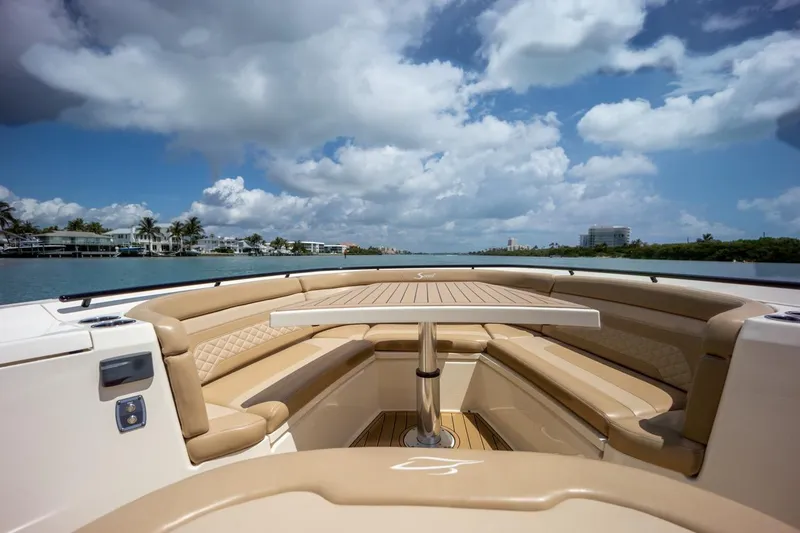 Slide: The Image of 2022 Scout 330 LXF boat with luxurious seating and scenic water view. - 10