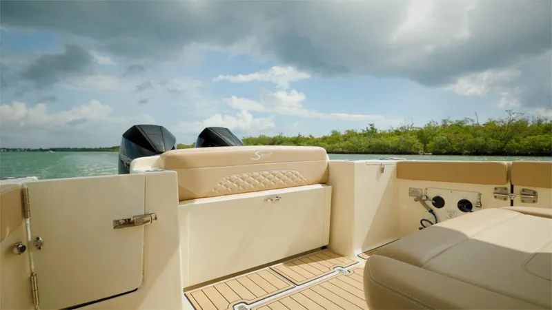 Slide: The Image of 2022 Scout 330 LXF boat interior with dual engines and scenic water view. - 16