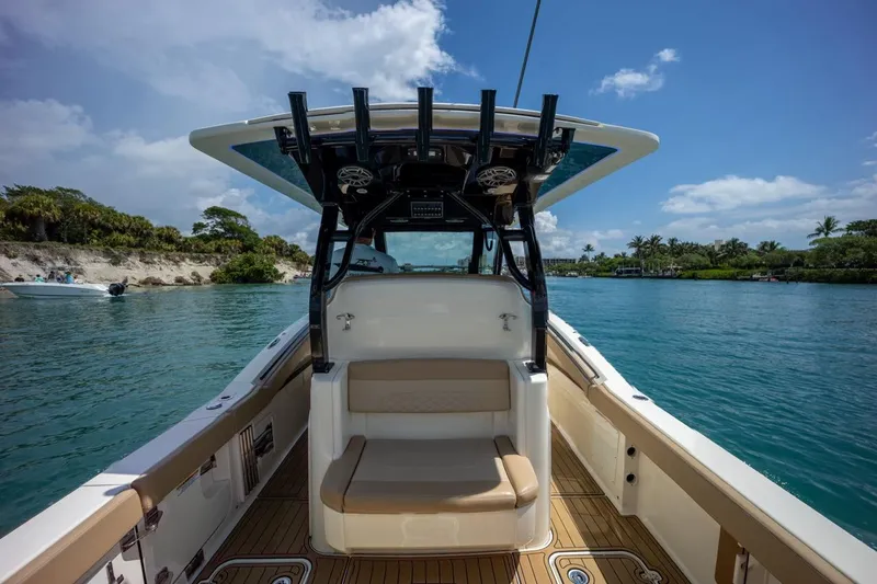 Slide: The Image of 2022 Scout 330 LXF boat interior with seating, on a sunny day. - 8