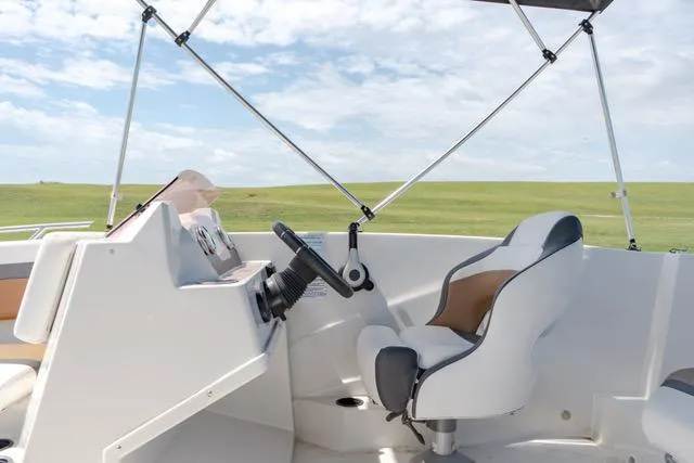 Slide: The Image of 2022 Starcraft SVX 171 OB boat interior with steering wheel and captain's chair. - 9