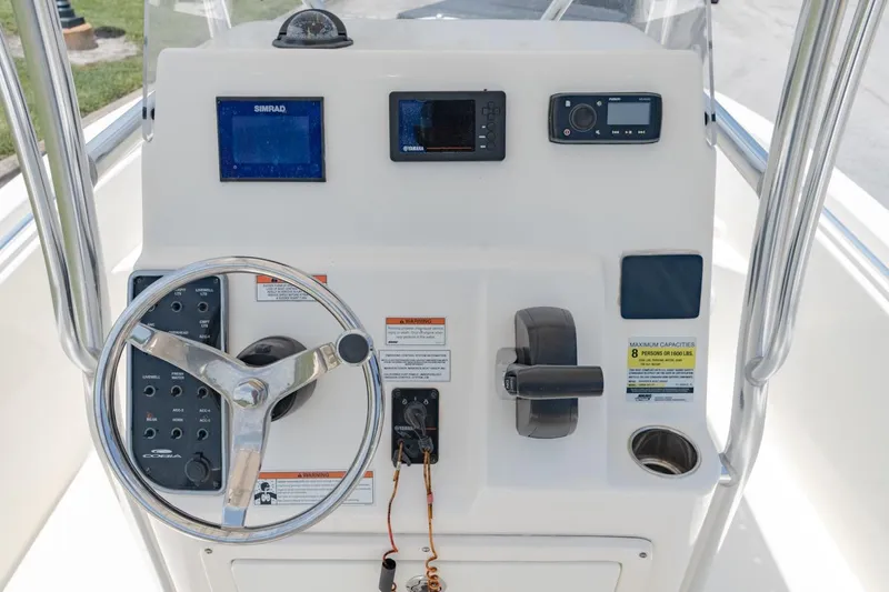 Slide: The Image of Cobia 201 Center Console 2021 boat dashboard with steering wheel, controls, and navigation equipment. - 15